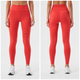 En kvinde ses forfra og bagfra, stående foran en ensfarvet hvid baggrund, iført 7 Days Active’s Performance Tight (Dame) i farven Cherry Tomato samt hvide sneakers. Disse knaldrøde tights med høj talje har sidelommer og et lille logo på venstre lår, hvilket gør dem ideelle til træning.