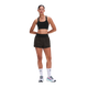 En kvinde står foran en hvid baggrund iført en sort sports-BH, ON Performance Volt Shorts Dame i farven Espresso, hvide strømper med kort skaft og hvide og blågrønne løbesko. Hun har armene over kors og kigger lige frem.