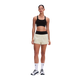 En person står med ansigtet vendt fremad iført en sort sports-BH, ON Performance Volt Shorts Dame Hare med sort linning, hvide strømper og hvide sportssko foran en ensfarvet hvid baggrund.