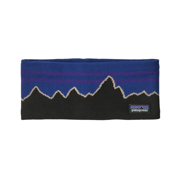 Patagonia Powder Town-pandebåndet, unisex i farven Classic Fitz Roy: P6 Blue, har et iøjnefaldende sort og blåt strikmønster med et takket bjergmønster og er afsluttet med et lille rektangulært Patagonia-logo på forsiden – en kombination af stil og funktionalitet til alle dine udendørs eventyr.