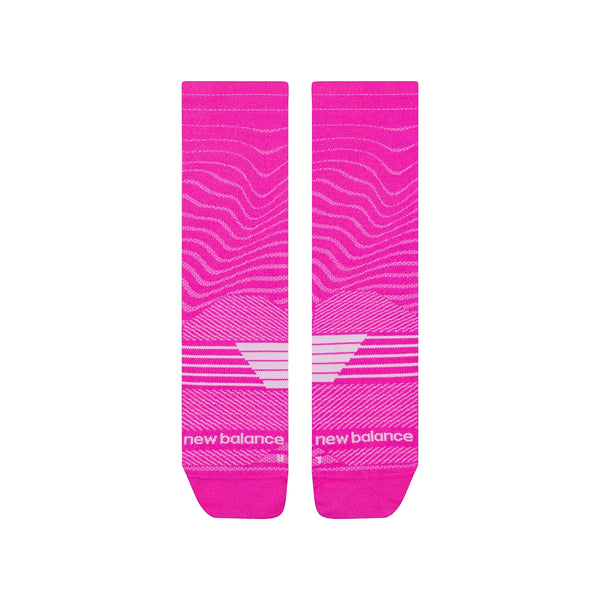 Et par lyserøde New Balance Pro Run Crew Socks, Unisex, i Pink Heat, med hvide geometriske linjer og New Balance-logo og -tekst nær tæerne, vist side om side på en hvid baggrund.