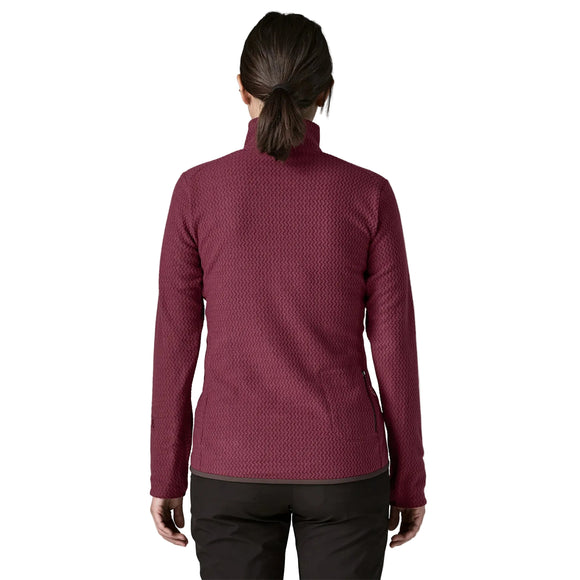 En person set bagfra, iført en dybrød Patagonia R1 Air Zip Neck, Dame, Berry Fig-fleece med et struktureret chevronmønster og sorte bukser.