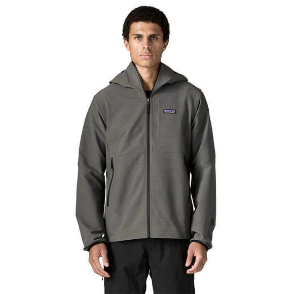 En person står med ansigtet vendt fremad og er iført en Patagonia R1 TechFace Hoody, Herre, i farven Forge Grey samt sorte bukser. Hoodien har et lille rektangulært Patagonia-logo på venstre bryst. Baggrunden er ensfarvet hvid.