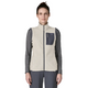 En person iført en Patagonia R1 Air Vest, Dame i farven Birch White, med en grå brystlomme med lynlås, over en grå langærmet skjorte, stående foran en ensfarvet hvid baggrund.