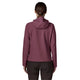 En person står med ryggen til kameraet og har en Berry Fig Patagonia R1 CrossStrata Hoody og mørke bukser på. Håret er bundet tilbage i en lav hestehale. Baggrunden er helt hvid.