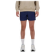 En person står med ansigtet fremad iført en beige sweatshirt, New Balance RC Short 5" Herre Navy/Salte Grey, hvide strømper og hvide sneakers. Billedet er beskåret over skuldrene.