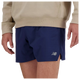 En person er iført en beige sweatshirt og New Balance RC Short 5" herre i navy/saltgrå, vist fra taljen til midt på låret med armene afslappet i siden.
