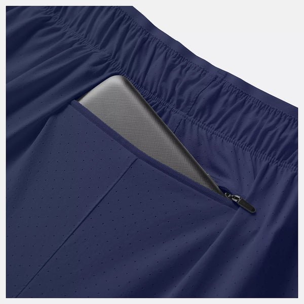 Nærbillede af New Balance RC Short 5" til mænd i Navy/Salte Grey med elastisk linning og en lynlåslomme, der er delvist åben, så man kan se en grå tablet indeni.