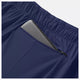 Nærbillede af New Balance RC Short 5" til mænd i Navy/Salte Grey med elastisk linning og en lynlåslomme, der er delvist åben, så man kan se en grå tablet indeni.