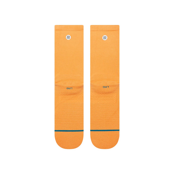 Et par Stance Run Light Crew, Herre, Mango strømper ligger fladt side om side på en hvid baggrund. De har hver især et lille cirkulært logo øverst og en tynd blågrøn stribe over tæerne.