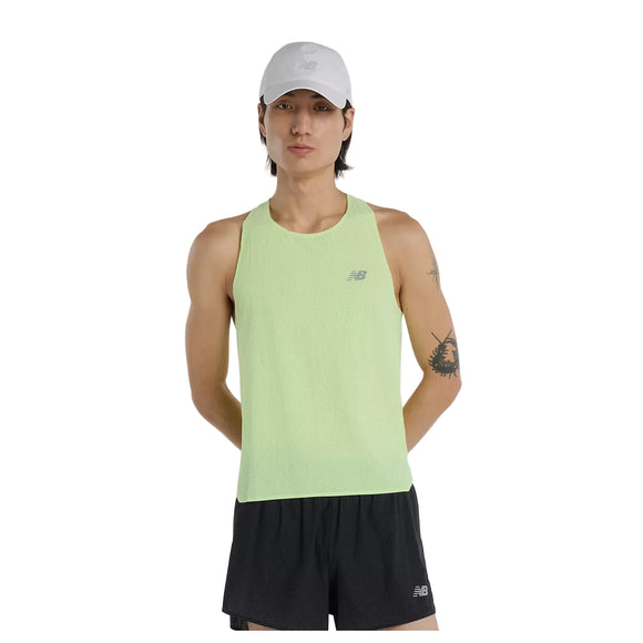 En person med langt mørkt hår er iført en lysegrøn New Balance Race Day Ultra Light Singlet, Herre, Afterglow, sorte shorts og en hvid kasket. Vedkommende har en tatovering på venstre overarm og står med hænderne på ryggen mod en hvid baggrund.