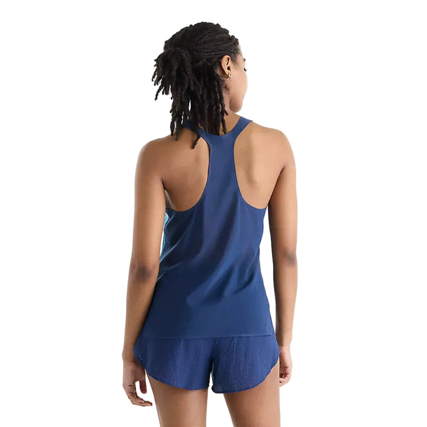 En person med mørkt, skulderlangt hår ses bagfra iført New Balance Race Day Ultra Light Printed Singlet, Dame, Altitude – en blå tanktop med racerryg – kombineret med matchende blå sportsshorts foran en ensfarvet hvid baggrund, hvilket illustrerer den strømlinede stil i New Balance Race Day-løbetøj til kvinder.