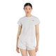En kvinde kigger fremad iført New Balance Race Day Ultra Light T-Shirt, Dame, Grey Matter, med matchende shorts og røde New Balance-logoer. Den ultralette t-shirt har NB ICEx-teknologi. Baggrunden er almindelig hvid.