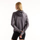 Grå New Balance RC Essential Heat Grid-hoodie, Neptune Grey, med tommelfingerhuller, båret sammen med sorte shorts.
