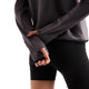En grå New Balance Rc Essential Heat Grid-hoodie med tommelfingerhuller, kombineret med sorte shorts.