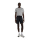 En mand står vendt fremad iført en lysegrå T-shirt med korte ærmer, et par New Balance Rc Essential Short 7" til mænd i sort, hvide strømper og hvide sportssko foran en ensfarvet hvid baggrund.