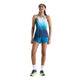 En person står og smiler iført en ærmeløs blå sportstrøje med farveovergang, Rc Ultra Light Printed Short 3″, Dame, Altitude fra New Balance samt flerfarvede løbesko foran en ensfarvet hvid baggrund. De behagelige New Balance-shorts passer perfekt sammen med hvide sokker og skaber et friskt og sporty look.