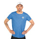 En mand iført en hvid kasket og en Saysky Reactive Flow T-shirt, Herre, Blue Aop, står med hænderne i siden. Han har tatoveringer på begge arme og et kortklippet skæg. Baggrunden er helt hvid.