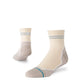 På billedet ses et par Stance Reflector Light Quarter unisex-sokker i farven »Croissant«, der er fremstillet i cremefarvet stof med grå striber ved manchetten og beige detaljer ved hæl og tå – den ene sok står oprejst, mens den anden er vinklet for at fremhæve siden og sålen. Disse sokker er designet som løbesokker og tilbyder enestående åndbarhed, så dine fødder forbliver komfortable under aktivitet.