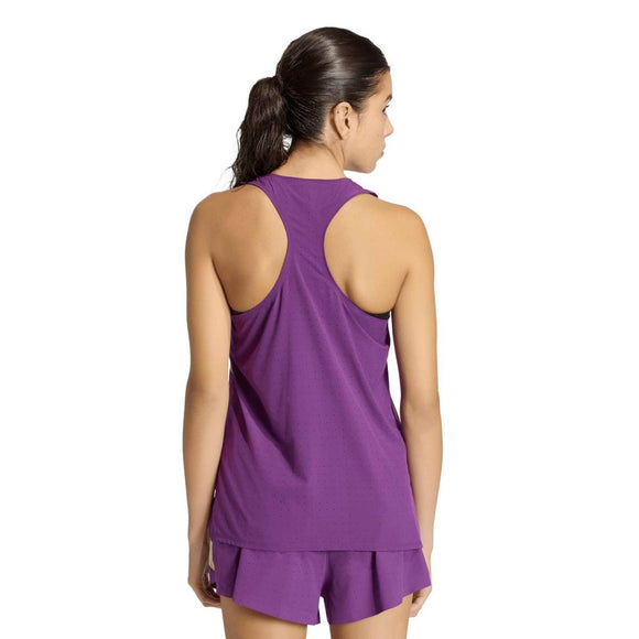 En kvinde med mørkt hår, der er bundet tilbage, står med ryggen til kameraet iført en violet Adidas Rtr Tank til kvinder på en almindelig hvid baggrund.