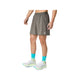 En person iført ASICS Road 2-N-1 7In-shorts til mænd i farven Truffle Grey, blågrønne sokker med grønne detaljer og hvide løbesko står foran en ensfarvet hvid baggrund, hvor man kan se vedkommende fra midten af overkroppen og ned til fødderne.