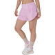 En person står iført ASICS Road 3.5In Shorts Dame i farven Hazy Lilac, beige strømper og hvide sportssko med lyserøde detaljer. Billedet viser personens underkrop foran en ensfarvet hvid baggrund.