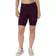 En person har Asics Road High Waist 8In Sprinter, Dame, mørk auberginefarvede tights og beige løbesko på og står foran en ensfarvet hvid baggrund. Personens hoved og underben er ikke synlige.