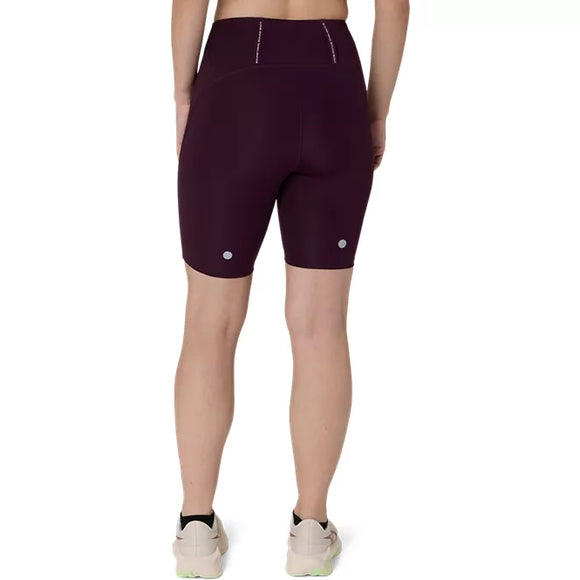 Man ser en kvinde bagfra, iført mørke, auberginefarvede ASICS Road High Waist 8In Sprinter-tights og lyse løbesko, mens hun står foran en ensfarvet hvid baggrund.