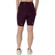 Man ser en kvinde bagfra, iført mørke, auberginefarvede ASICS Road High Waist 8In Sprinter-tights og lyse løbesko, mens hun står foran en ensfarvet hvid baggrund.