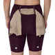 Der ses en person set bagfra iført ASICS Road High Waist 8In Sprinter-shorts til kvinder i farven Dark Aubergine. En beige skjorte er stukket ned i linningen, og der ses to reflekterende prikker på den nederste del af løbetights til kvinder.