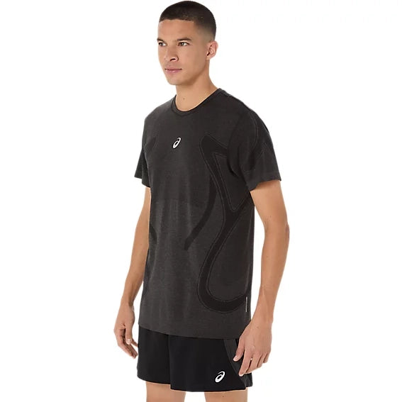 En mand iført en Asics Road Seamless Ss Top, Herre, Performance Black og sorte shorts med Asics-logo stod let drejet mod venstre. Det svedtransporterende løbetøj fremhæves på en helt hvid baggrund.