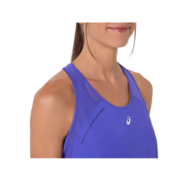 En kvinde iført en Asics Road Tank, Dame i Cobalt Burst med "SOUND MIND, SOUND BODY" nær venstre skulder. Billedet viser hende fra skuldrene og op, mens hun smiler blidt og fremhæver komfort og åndbarhed.