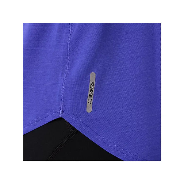 Nærbillede af undersiden af Asics Road Tank, Dame, i Cobalt Burst, der viser et lille reflekterende ACTIBREEZE-mærke for åndbarhed. En del af de sorte sportsbukser er også synlige i bunden.