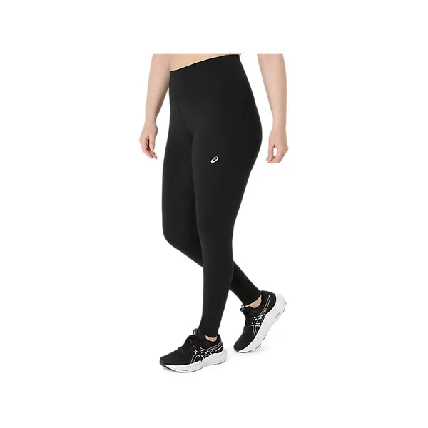 En person iført ASICS Road Winter High Waist Tights til kvinder i farven Performance Black og sorte løbesko med hvide såler står foran en hvid baggrund. Tightsene har et lille ASICS-logo på det øverste lår, og personens overkrop og ansigt er ikke synlige.