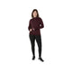 En person med krøllet hår er iført en langærmet, rødbrun sportsbluse og et par ASICS Road Winter High Waist Tights til kvinder i farven Performance Black. Personen står foran en ensfarvet hvid baggrund og ser fremad med hænderne hvilende tæt ved hofterne.