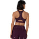 En kvinde med kort, mørkt hår ses set bagfra, iført Asics Road Compression Bra, Dame, i farven Dark Aubergine – perfekt til løb. Det matchende sæt har reflekterende detaljer og skiller sig ud mod en ensfarvet hvid baggrund.