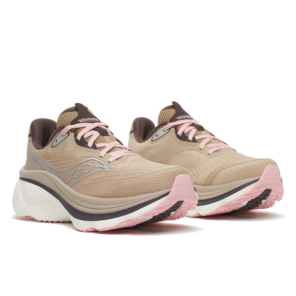 Et par Saucony Hurricane 26 Dame Saddle/Touch-løbesko med beige overdel, lyserøde og hvide såler, lyserøde snørebånd og brune detaljer, vist fra en trekvart-vinkel forfra på en hvid baggrund.