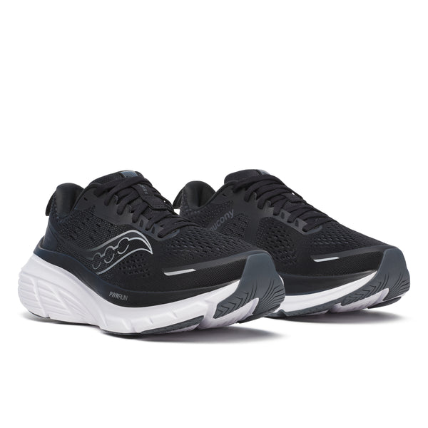 Et par Saucony Guide 18 Dame løbesko i sort/hvid med sølvfarvede detaljer, overdel i mesh, tykke polstrede mellemsåler og Saucony-logoer på siderne, vist side om side på en hvid baggrund.