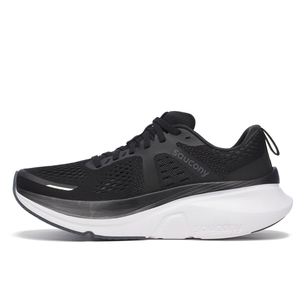 Saucony Guide 18 løbesko til kvinder i sort/hvid har en overdel i mesh, sorte snørebånd og en tyk hvid sål, set fra siden på en hvid baggrund.