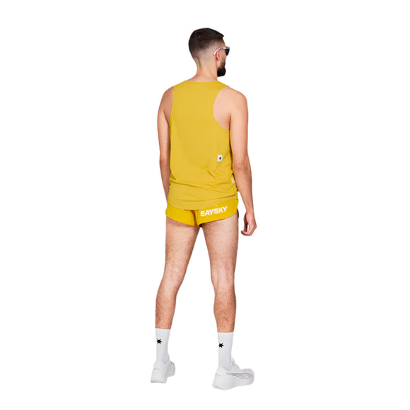 En mand med kort hår og skæg kigger væk, iført en gul tanktop og Saysky Combat Shorts 2" Herre Yellow med hvid Saysky-tekst, samt hvide strømper med stjernelogo og sneakers, alt sammen på en hvid baggrund.