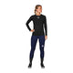 En person står let foroverbøjet iført Saysky Mesh Base Layer LS (Unisex, sort), mørkeblå leggings, sorte og hvide sokker og sorte sportssko på en hvid baggrund.