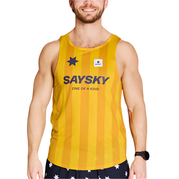 En mand i Saysky Stripe Combat Singlet Herre, Yellow Aop - en fugttransporterende singlet til mænd med "ONE OF A KIND" og et stjernelogo - parret med sorte shorts med hvide stjerner, står på en hvid baggrund.