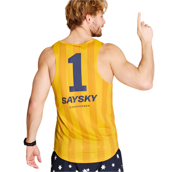 En mand er iført Saysky Stripe Combat Singlet, Herre, Yellow Aop med "SAYSKY COPENHAGEN" og nummer 1 på ryggen, der peger opad. Han har også mørke shorts på dekoreret med hvide stjerner.
