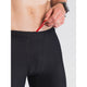En person i bar overkrop justerer den røde løbegang på Fusion's Short Tights Advanced, Unisex, Superblack. De bærer et armbåndsur og en ring på deres venstre hånd. Den enkle hvide baggrund fremhæver disse perfekte tights til træning.