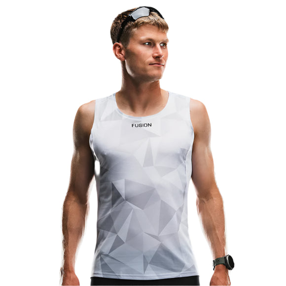 En mand iført Fusion TEMPO! Run Singlet, Unisex, White/Grey - med geometriske mønstre og kendt for hurtig fugttransport - står på en hvid baggrund og kigger til siden med et sort sportsur og solbriller på hovedet.
