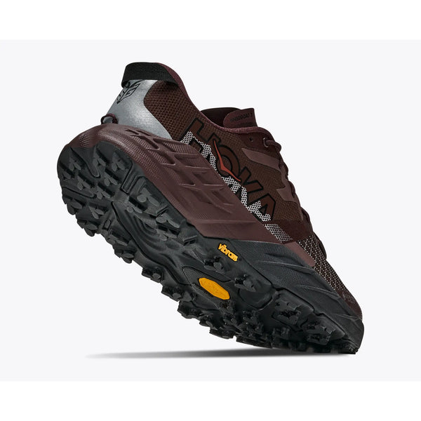 Her ses en enkelt Speedgoat 7 GTX trailsko til kvinder i farven Deep Mauve / Black fra Hoka, fotograferet fra en lav vinkel, hvilket fremhæver den robuste Vibram-sål og detaljerne ved hælen. Skoen har Hoka-logoet på siden, åndbare mesh-paneler og førsteklasses GORE-TEX-beskyttelse.