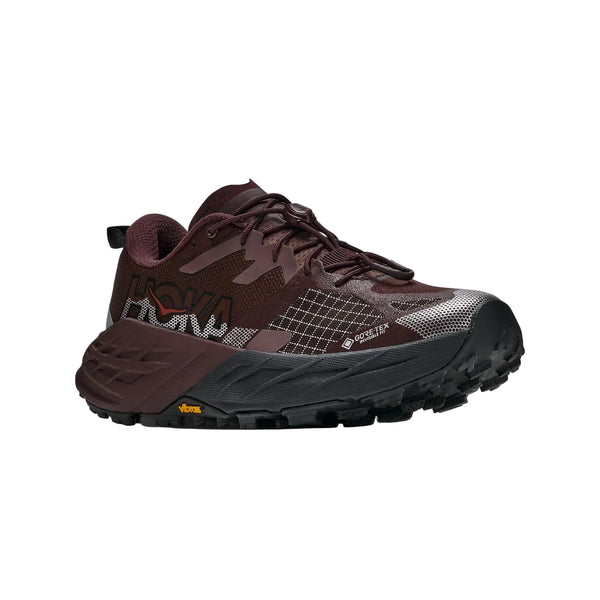 Vi præsenterer Hoka Speedgoat 7 GTX til kvinder i farven Deep Mauve / Black – udviklet til krævende stier. Denne sportssko har en slidstærk sort Vibram-sål med robust mønster, en åndbar overdel i mesh med markante geometriske detaljer og det karakteristiske Hoka-logo på siden. GORE-TEX-overdelen på tåen sikrer pålidelig vandtæt beskyttelse, mens sorte snørebånd og et iøjnefaldende gult Vibram-logo fuldender det præstationsorienterede design.