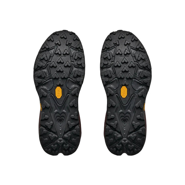 Et par sorte Hoka Speedgoat 7 GTX-såler til kvinder i farven Deep Mauve / Black med strukturerede mønstre på sålen – herunder hjerteformede og geometriske mønstre – vises side om side på en hvid baggrund. Disse såler er inspireret af avanceret trailsko-teknologi og tilbyder det pålidelige greb og den GORE-TEX-lignende holdbarhed, der kendetegner Hokas berømte ydeevne, hvilket gør dem ideelle til alle forhold.