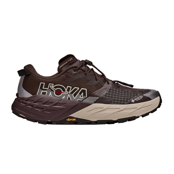 Her ses et profilbillede af en Hoka Speedgoat 7 GTX trailsko til mænd i farvekombinationen Spiced Chocolate / River Rock Grey, med en sort og lysebrun sål, et markant Hoka-logo på siden, et GORE-TEX-mærke, detaljer i gittermønster samt et Vibram-logo på ydersålen.