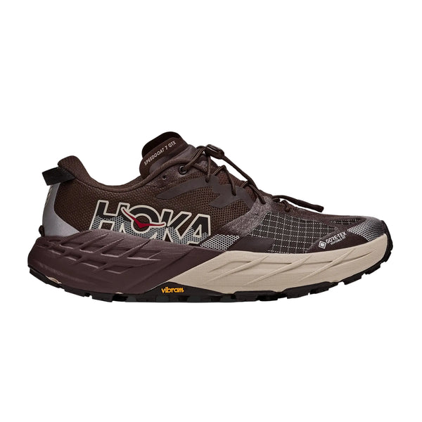 Her ses et profilbillede af en Hoka Speedgoat 7 GTX trailsko til mænd i farvekombinationen Spiced Chocolate / River Rock Grey, med en sort og lysebrun sål, et markant Hoka-logo på siden, et GORE-TEX-mærke, detaljer i gittermønster samt et Vibram-logo på ydersålen.